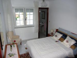 a bedroom with a bed and a chair and a window at Apartamentos Playa Monte Pindo - Morada Druida in O Pindo