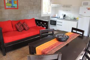 a living room with a red couch and a table at Entrepinos Apart in Mar Azul