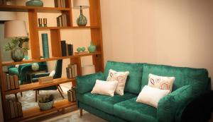 查韦斯Castelo Hotel的客厅配有带枕头的绿色沙发