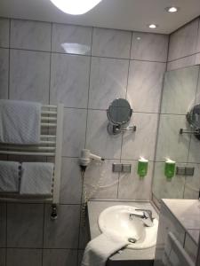 a bathroom with a sink and a mirror at Parkhotel "Am Schänzchen" in Andernach