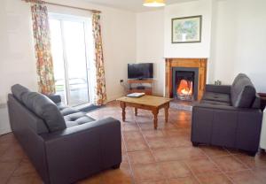 a living room with two couches and a fireplace at Ballybunion Holiday Homes No 27 in Ballybunion