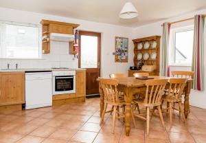 a kitchen with a wooden table and chairs at Ballybunion Holiday Homes No 27 in Ballybunion