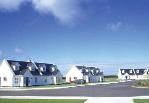 una fila de casas con un coche aparcado en una entrada en Ballybunion Holiday Homes No 27, en Ballybunion