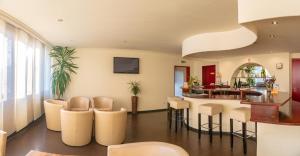 ein Wohnzimmer mit weißen Stühlen und einer Bar in der Unterkunft Hotel Milano in Hildesheim