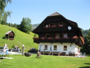 a house with flowers on the front of it at Ferienwohnung Lahnerhof in Arriach
