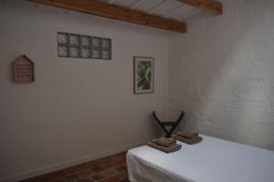 a white room with a bed with towels on it at Refugi Biniati Vell in Sant Lluis