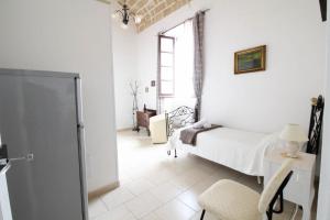 a bedroom with a bed and a chair and a window at Camera vista mare Holidayz in Gallipoli