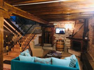 a living room with a blue couch and a staircase at Casa Los Laureles in Hinojedo