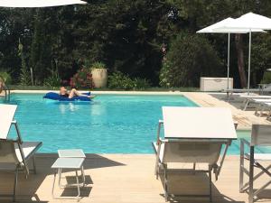 un homme qui se pose sur un radeau dans une piscine dans l'établissement Il Colle delle Terrazze, à Fano