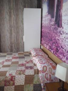 1 dormitorio con 1 cama y una pintura en la pared en Apartamentos Jardines de Llanes, en Pancar