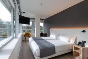 a bedroom with a large bed and a large window at Hotel Distrito Oeste in Donostia-San Sebastián