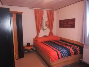 a bedroom with a bed with red sheets and a window at Haus Chrissy in Altmünster