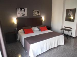 a bedroom with a large bed with red pillows at Hotel Marblau Tossa in Tossa de Mar