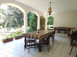 une table et des chaises assises sur une terrasse dans l'établissement Fertődi Kúria Vendégház, à Fertőd