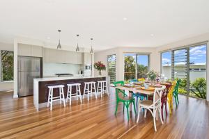 a kitchen and dining room with a table and chairs at Kilala - executive home in Port Macquarie