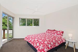 a white bedroom with a bed and a window at Kilala - executive home in Port Macquarie
