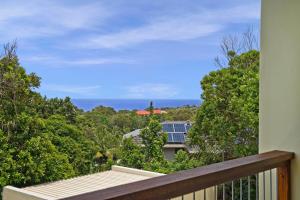 a balcony with a view of the ocean at Kilala - executive home in Port Macquarie