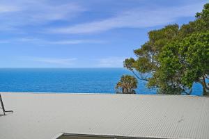 a white roof with the ocean in the background at Kilala - executive home in Port Macquarie