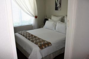 a bedroom with a large white bed with a window at 142 hermanus beach club in Hermanus