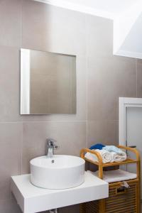 a bathroom with a white sink and a mirror at Lindos Del Mar Suites - Adults Only in Lindos