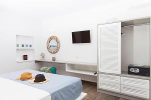 a bedroom with a bed with a hat on it at Lindos Del Mar Suites - Adults Only in Lindos