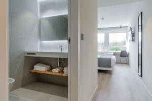 Un baño con lavabo y una cama en una habitación. en Hotel Distrito Oeste, en San Sebastián 37 fotos más