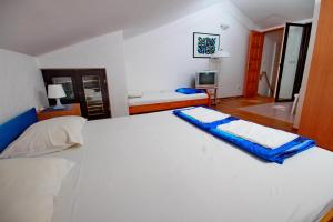 a bedroom with a large white bed in a room at Apartments Vuković in Petrovac na Moru