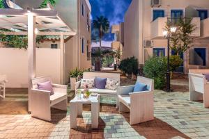 a patio with chairs and a table and an umbrella at Nana Angela Apartments in Hersonissos