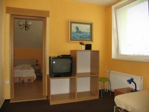 a living room with a tv and a bedroom at Penzión v Tatrách in Stará Lesná