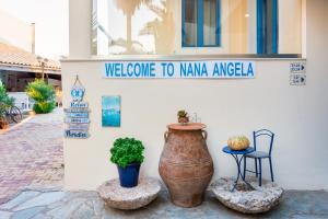 a sign on the side of a building with a large vase at Nana Angela Apartments in Hersonissos