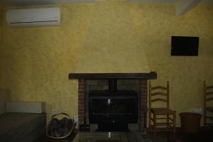 ein Wohnzimmer mit einem Kamin und einem TV in der Unterkunft Casa Rural Las Pegueras in Avila
