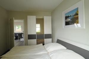 PritzerbeにあるFerienanlage Pritzerbeのベッドルーム1室(ベッド1台付)が備わります。壁に絵が飾られています。