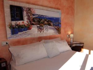 a bedroom with a bed and a painting on the wall at L' Arnia in Ome