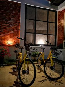 邦帕利的住宿－BA​ Apartment​ Flow​Suvarnabhumi，停在大楼前的两辆黄色自行车