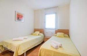 a bedroom with two beds with yellow sheets and a window at Canadell 1º 3ª in Palafrugell