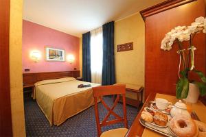 una camera d'albergo con letto e tavolo di Hotel Abacus a Porto Mantovano