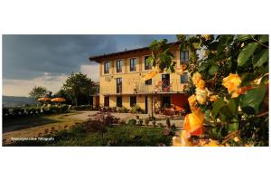 ein großes gelbes Gebäude mit einem Hof mit Blumen in der Unterkunft Agriturismo Bianconiglio in Monforte dʼAlba