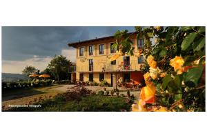 a large yellow building with a yard with flowers at Agriturismo Bianconiglio in Monforte dʼAlba