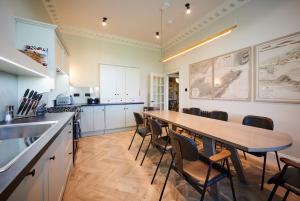 a kitchen with a long wooden table and chairs at Alexander Residence in Perth