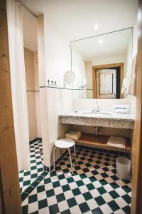 baño con lavabo, espejo y taburete en Hotel-Gasthof Weitgasser, en Mauterndorf