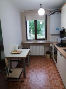 a small kitchen with a table and a window at Busteni Mountain Suites in Buşteni
