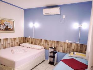 2 łóżka w pokoju z niebieskimi ścianami w obiekcie Pousada Boa Vista w mieście Cachoeira Paulista