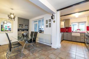 a kitchen and dining room with a glass table and chairs at Higherlands in Kingsley