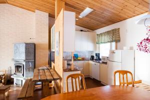 uma cozinha com uma mesa de madeira e uma cozinha com um fogão em Niemenkärki em Kouvola