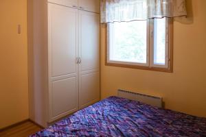 Schlafzimmer mit einem Bett und einem Fenster in der Unterkunft Niemenkärki in Kouvola