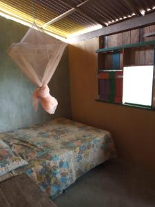 a bedroom with a bed with a mosquito net at La Luna Fortalezinha in Algodoal