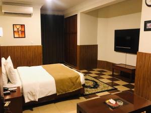 a hotel room with a bed and a tv at Hotel One Jinnah, Islamabad in Islamabad