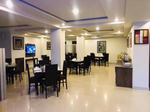 a dining room with black tables and chairs at Hotel One Jinnah, Islamabad in Islamabad