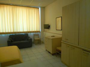 sala de estar con sofá, silla y escritorio en Polena Residence Hotel, en Marina di Montenero