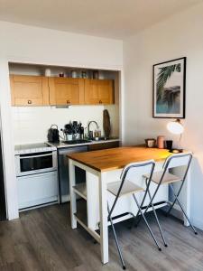 cocina con mesa de madera y 2 sillas en STUDIO FACE MER PORNICHET – VUE BAIE DE LA BAULE en Pornichet